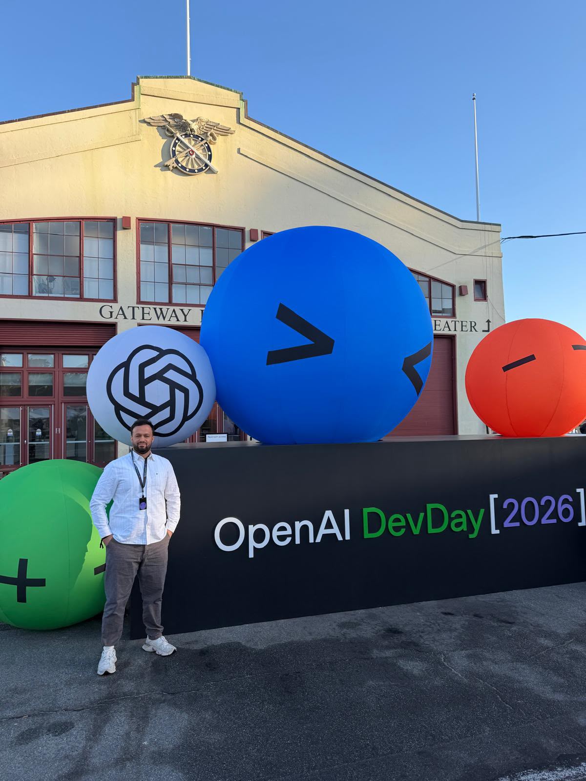 Mustafa Sahinli vor dem Schriftzug OpenAI DevDay 2026 in San Francisco